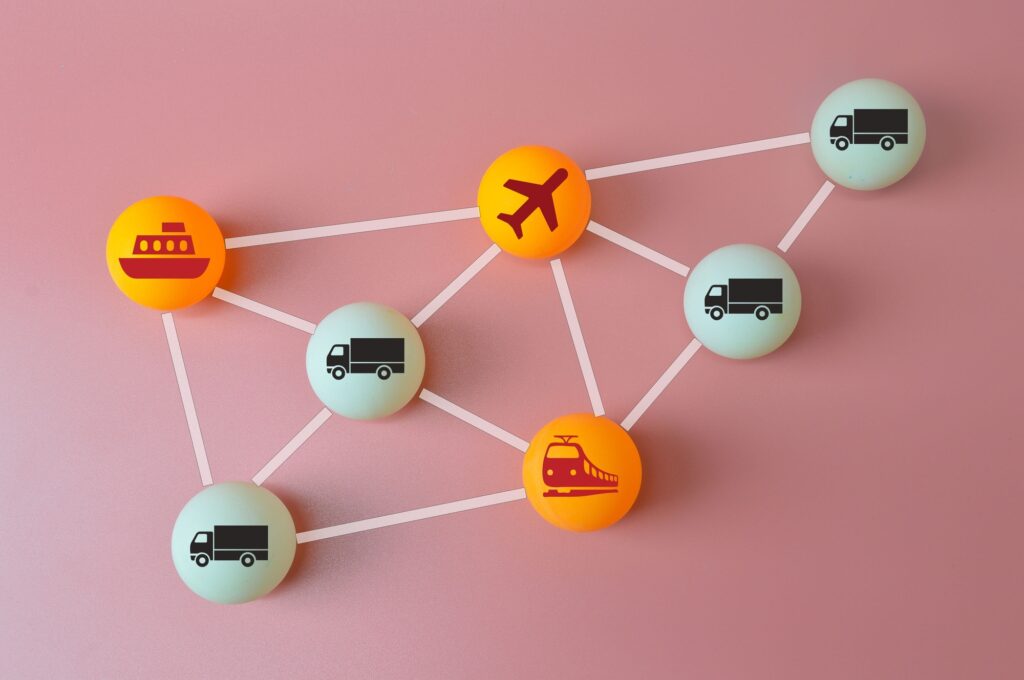 Connected logistics and supply chain concept. Table tennis ball with plane, trucks, train and ship s